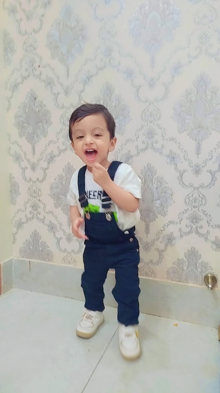 Ibrahim laughing in blue overalls